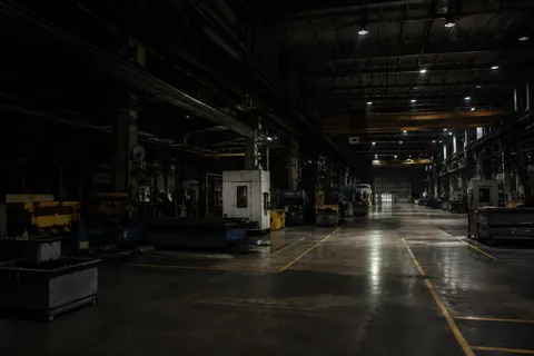 A machine shop after the shift, tooling under covers along a gangway marked out in yellow.
